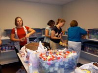 LUMC volunteers stocking food donations and packing food bags for local school children 